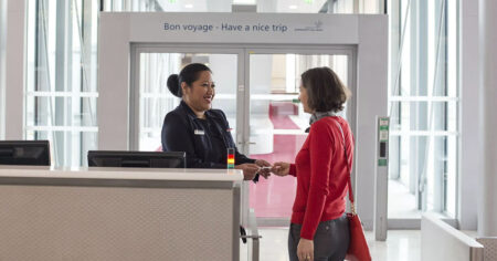 Une passagère reçoit son billet d'avion au comptoir d'embarquement