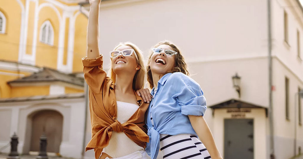 Deux femmes souriantes profitent d'une journée ensoleillée en ville