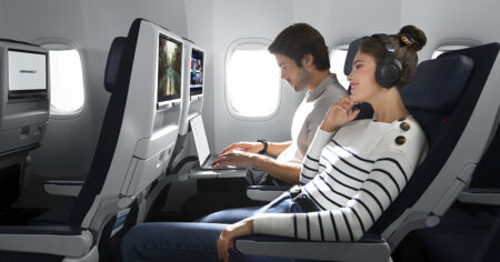 Air France - Deux personnes sont assises dans un avion, l'une utilisant un ordinateur portable et l'autre portant des écouteurs