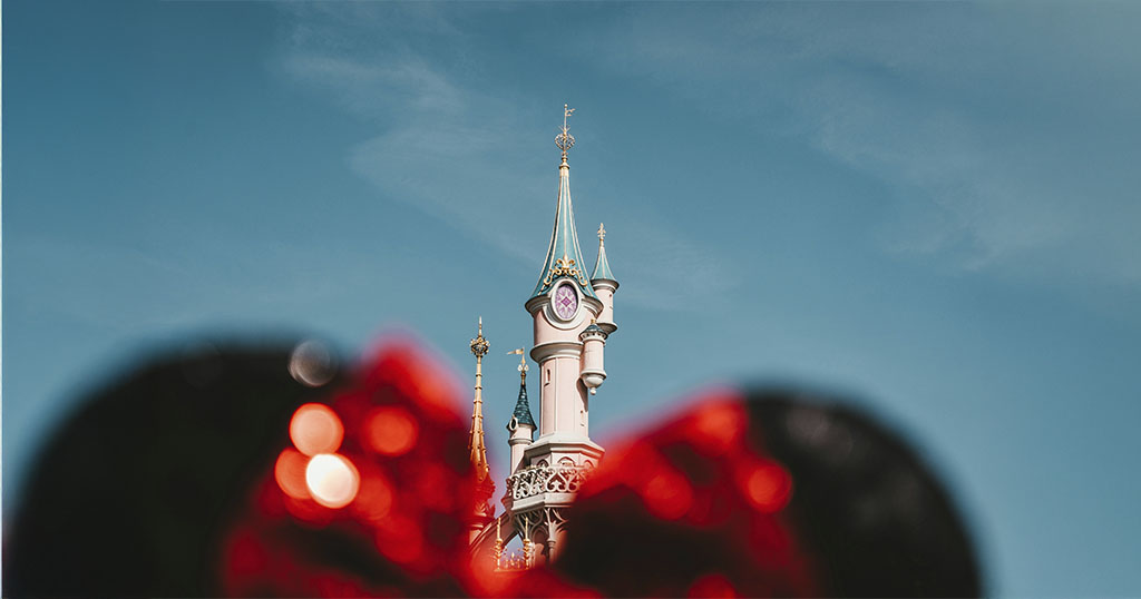 Un château féérique sous un ciel bleu, encadré par les oreilles de Minnie Mouse