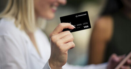 Une personne tient une carte de crédit Mooncard